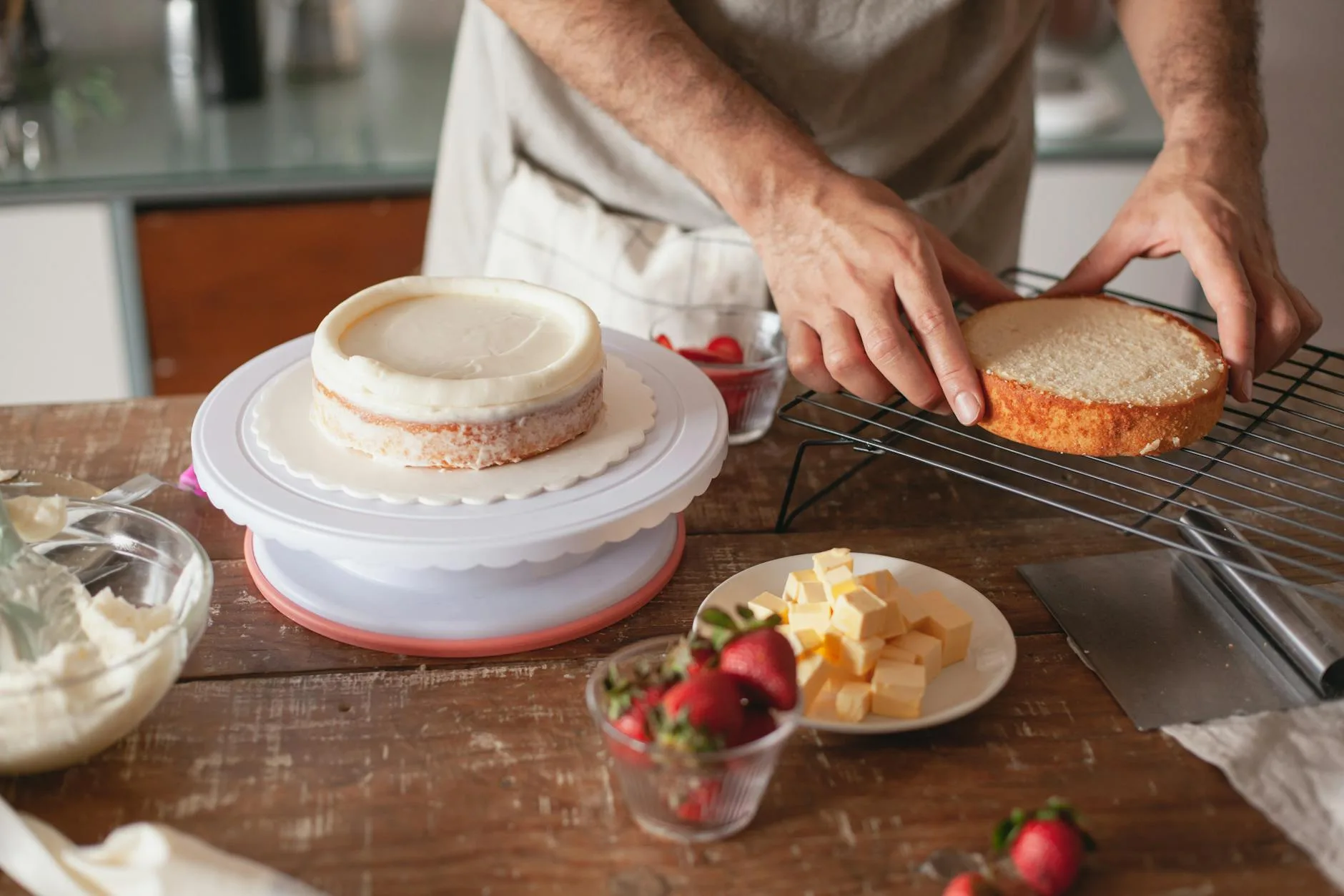 Dekorowanie warstwowego tortu kremem truskawkowym w domowej kuchni