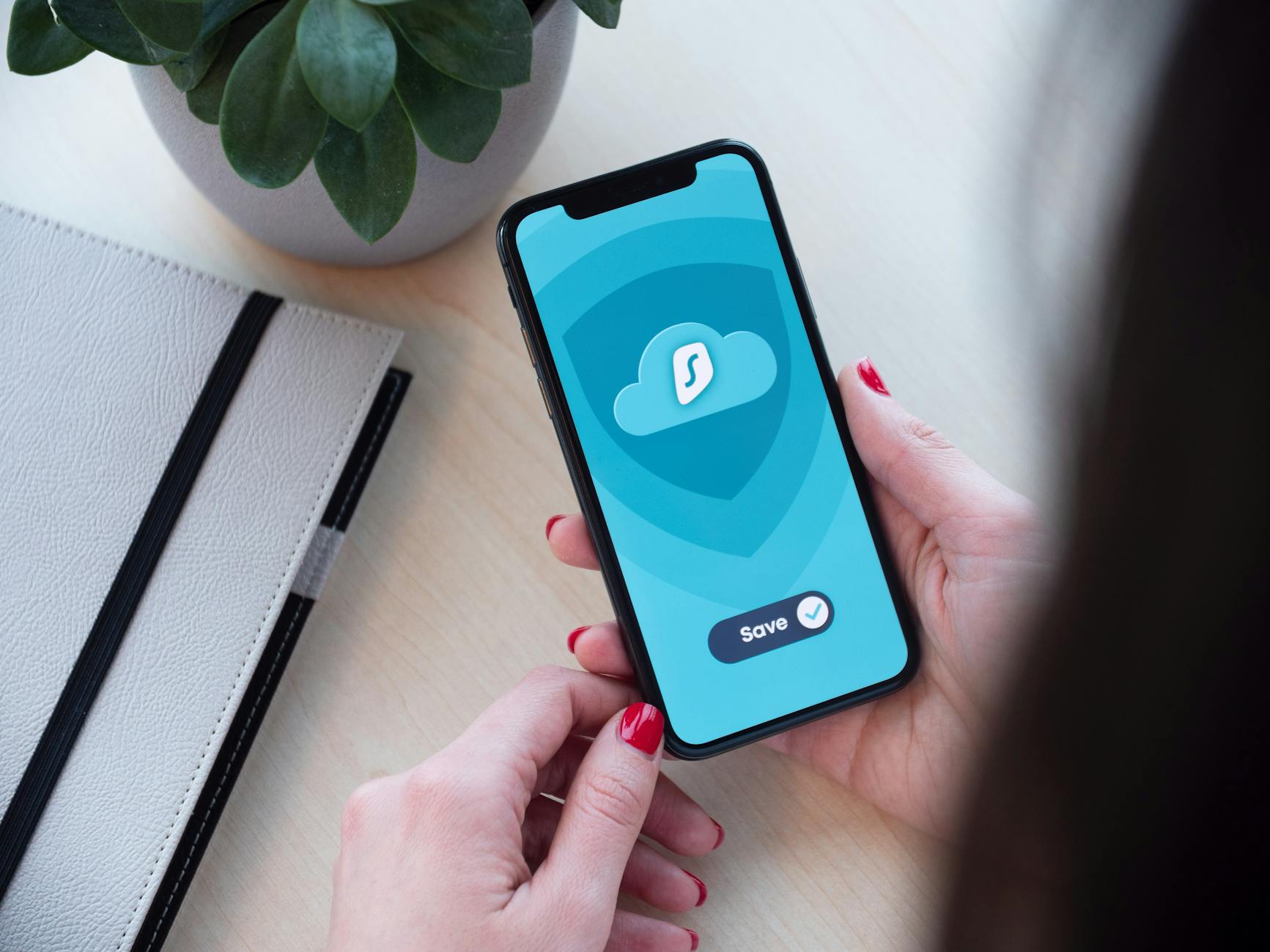 Kobieta trzyma smartfon z aplikacją szyfrującą dane