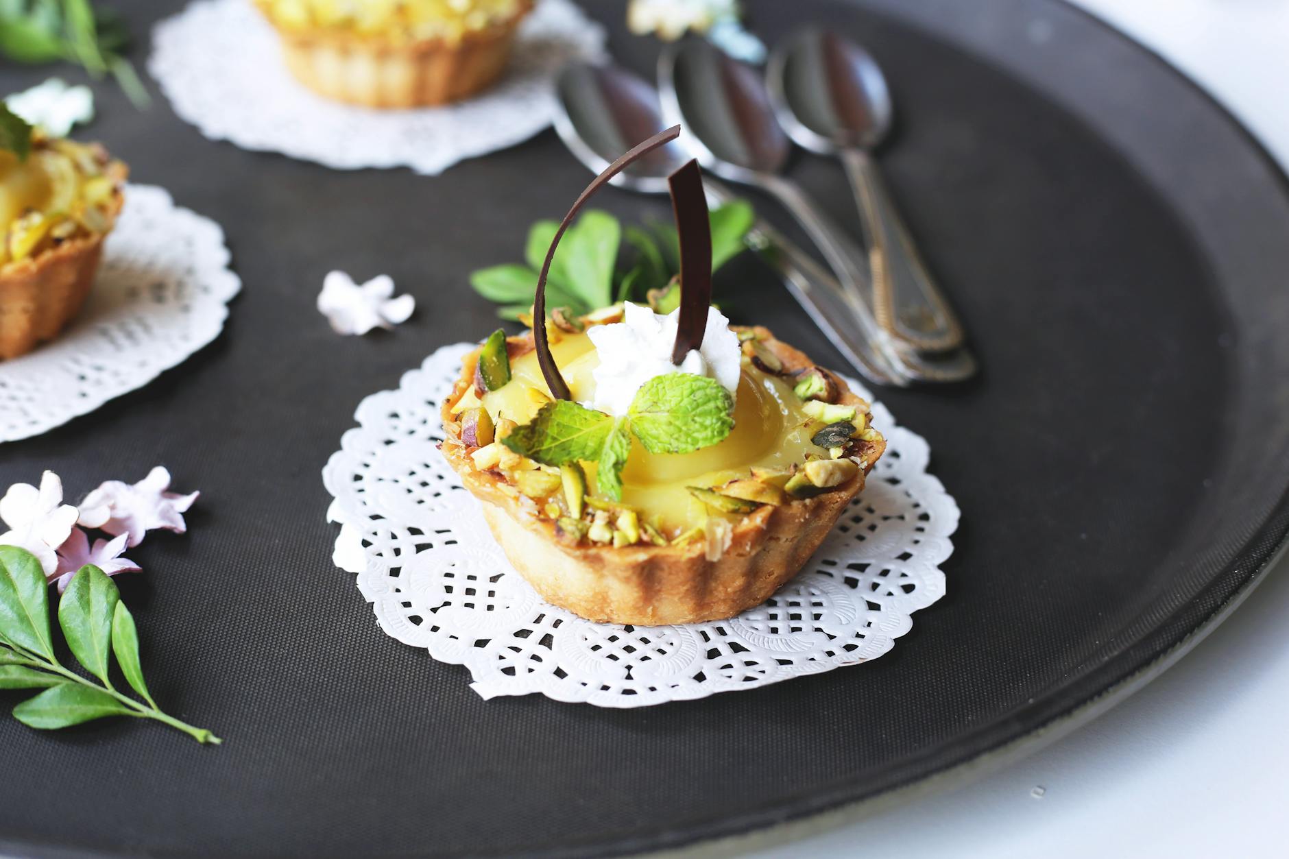 Tarta pistacjowa z czekoladą i miętą podana na ozdobnej serwetce
