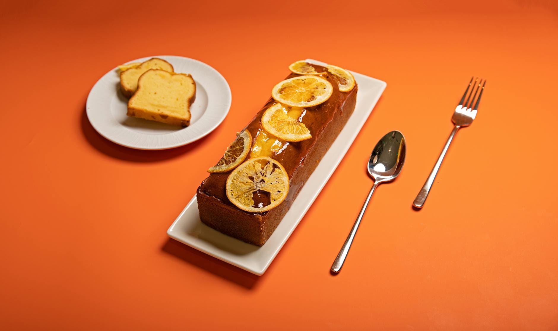 Babka cytrusowa z plasterkami pomarańczy na pomarańczowym tle