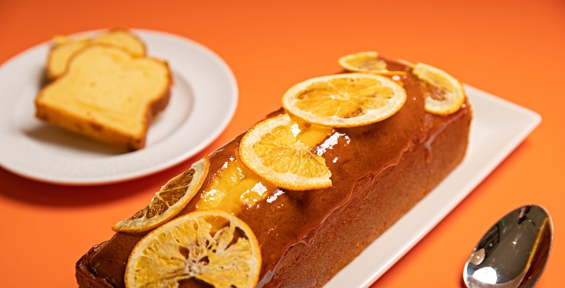 Babka piaskowa cytrynowa z plasterkami cytryny na białym talerzu