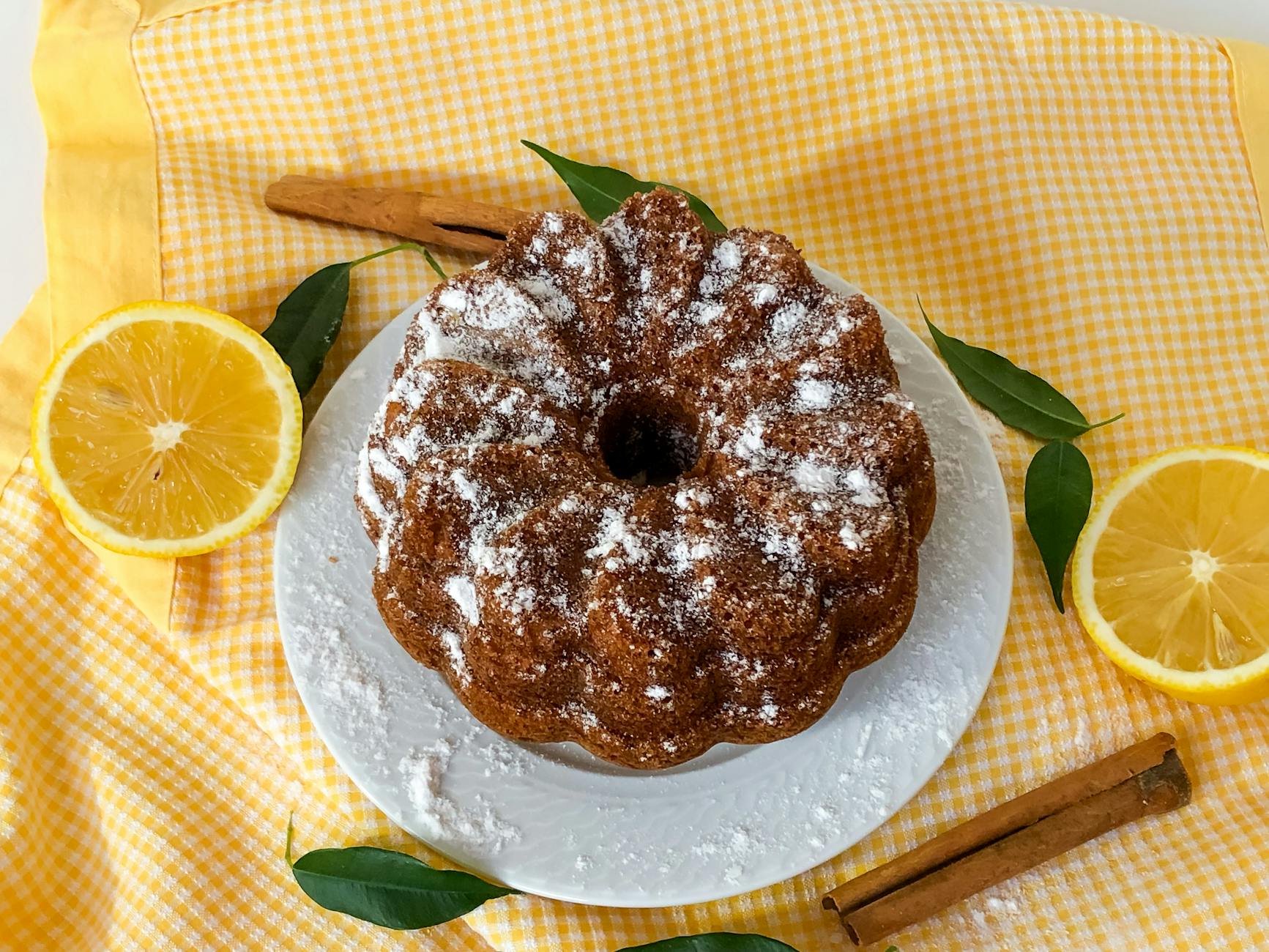 Domowa babka cytrynowa z makiem posypana cukrem na kraciastej ściereczce