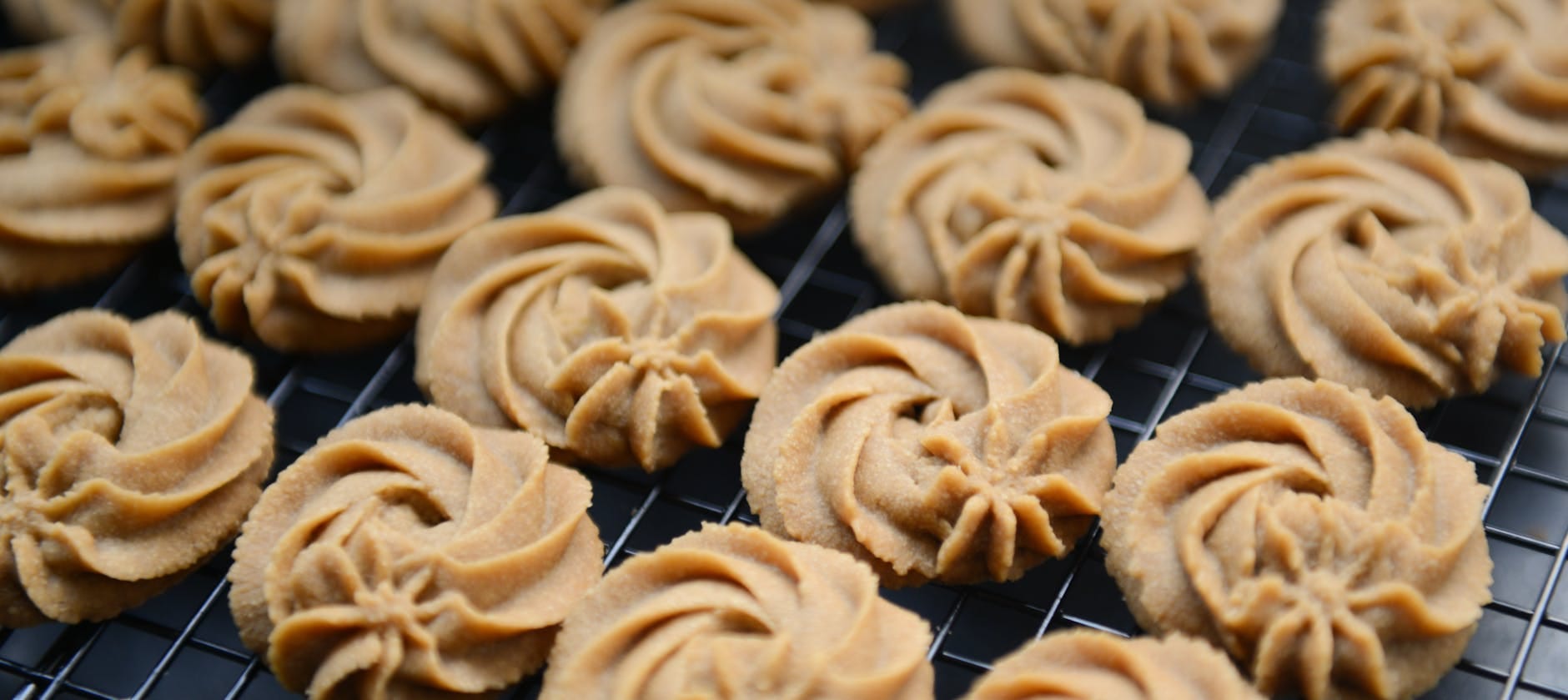 Świeżo upieczone kruche ciasteczka maślane na kratce do studzenia