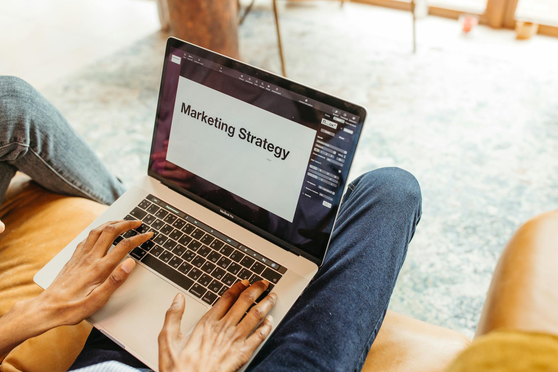 Dłonie przy laptopie z prezentacją strategii marketingowej online