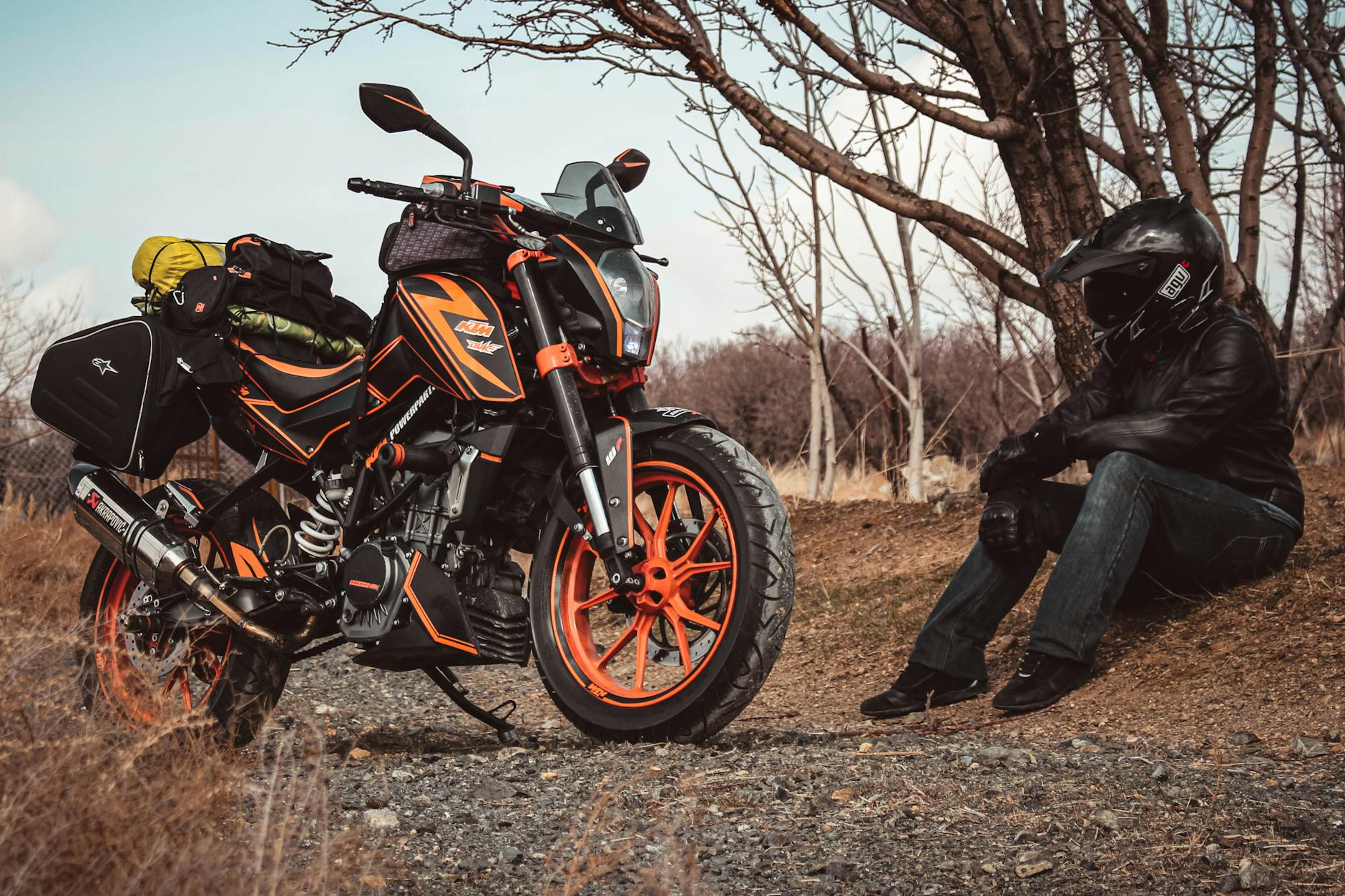 Motocyklista odpoczywa przy zapakowanym motocyklu KTM na wiejskiej drodze