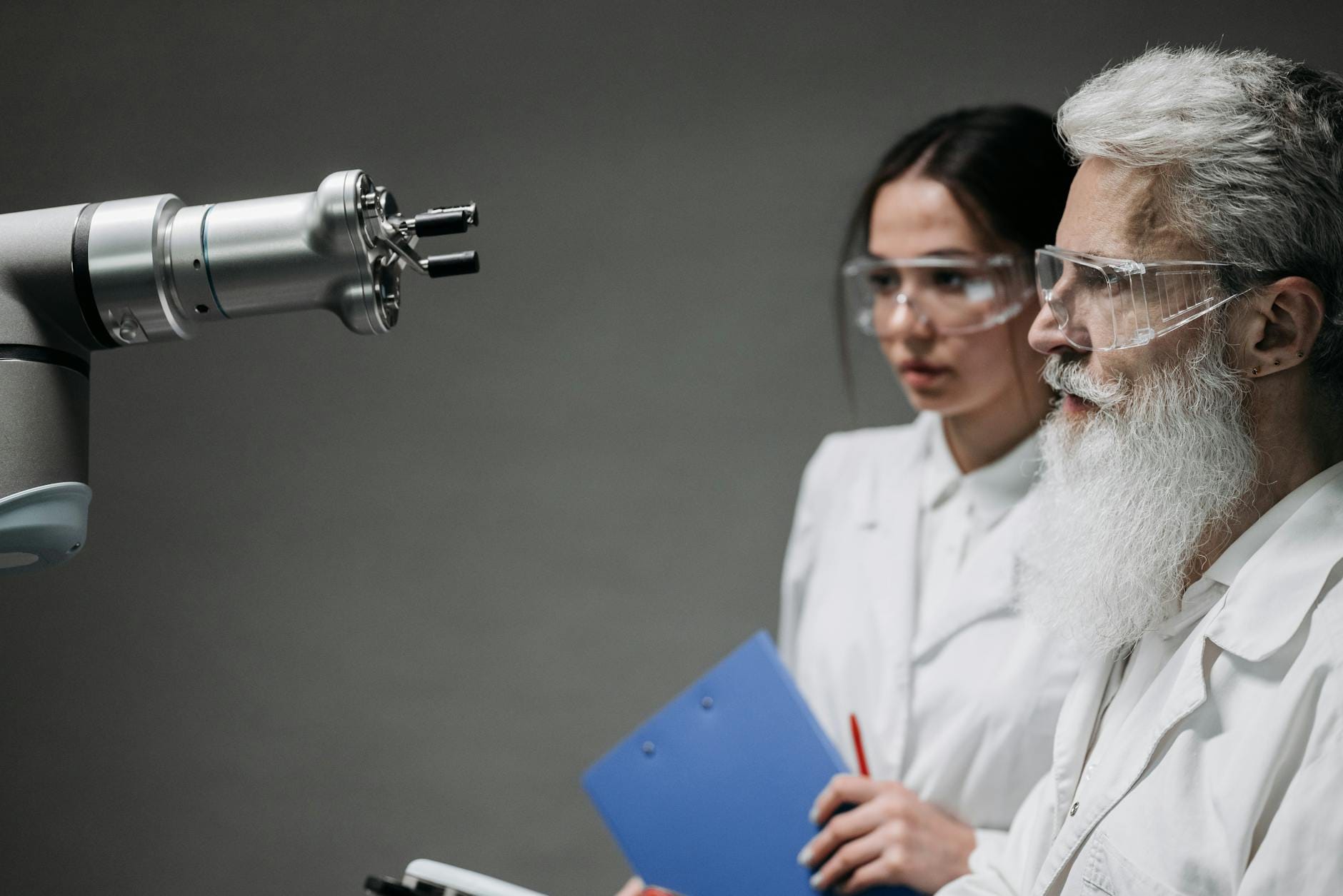 Naukowcy w laboratorium analizują ramię robota sterowanego sztuczną inteligencją