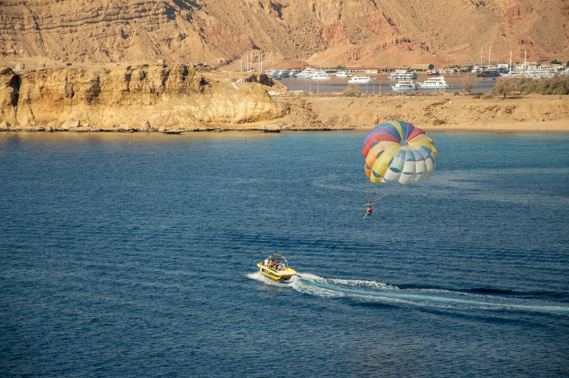 Parasailing nad morzem w Sharm El Sheikh z kolorowym spadochronem Parasailing nad morzem w Sharm El Sheikh z kolorowym spadochronem