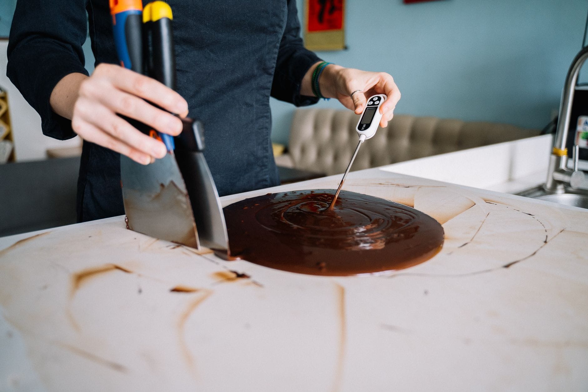 Temperowanie roztopionej czekolady na blacie kuchennym za pomocą skrobaka