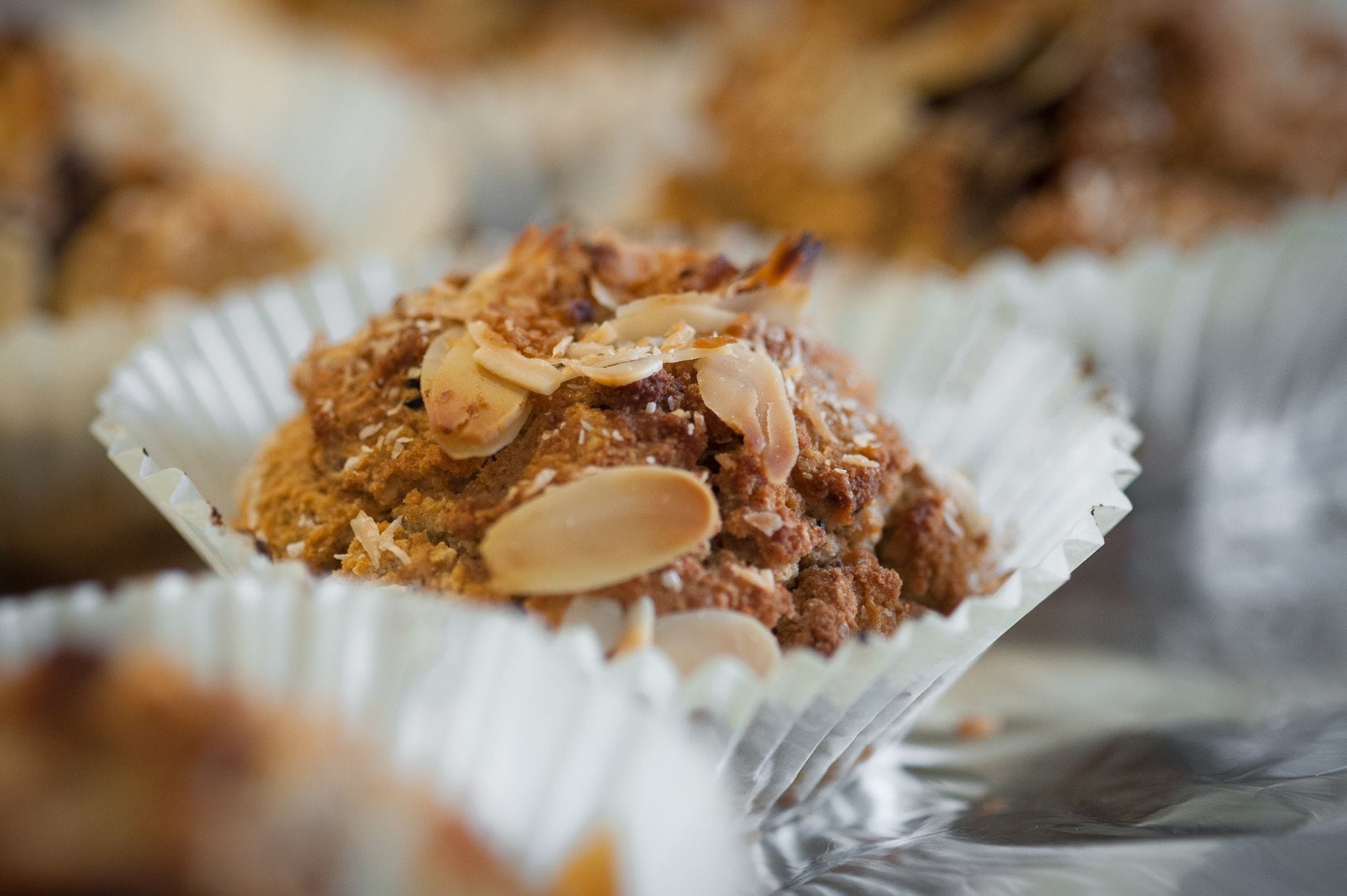 Bezglutenowe ciasteczka migdałowe z miodem i wanilią Zbliżenie na muffinkę z migdałami w papierowej papilotce